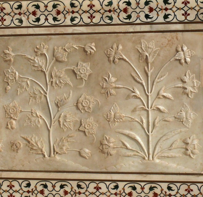 white marble dados that have been sculpted with realistic bas relief depictions of flowers and vines